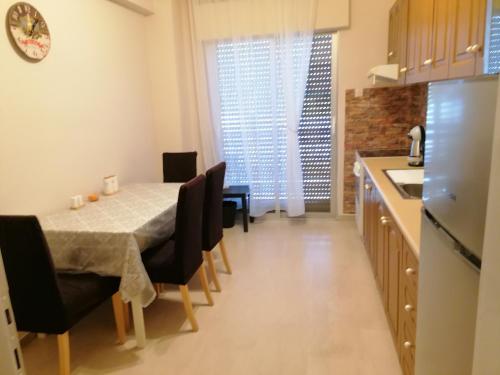 uma cozinha e sala de jantar com mesa e cadeiras em JP apartment em Michaniona