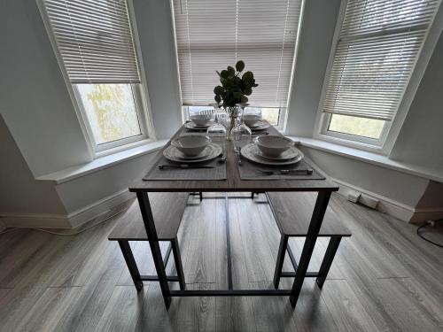 una mesa de comedor con un jarrón de flores. en Cosy apartment with parking close to Ipswich station, en Ipswich