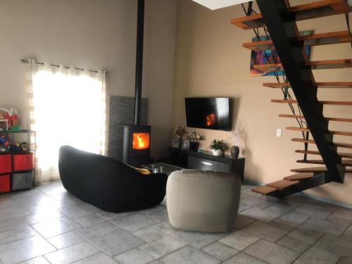 a living room with a black couch and a chair at La tanière in Hasparren