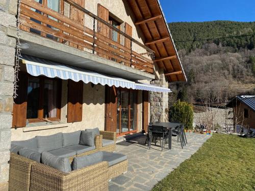 a patio of a house with a couch and a table at CHALET DON PAPA in Saint-Martin-Vésubie