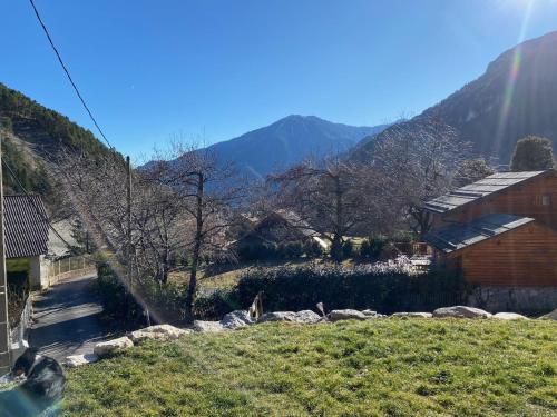a view of a hill with a house and mountains at CHALET DON PAPA in Saint-Martin-Vésubie