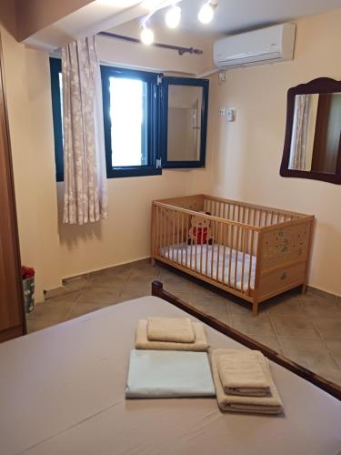 ein Babyzimmer mit einem Kinderbett und einem Spiegel in der Unterkunft Agistri SOPHIA'S APARTMENT in Skala