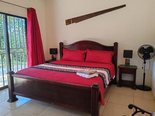 1 dormitorio con 1 cama grande con almohadas rojas en Casa para descanso en las montañas nicoyanas, 