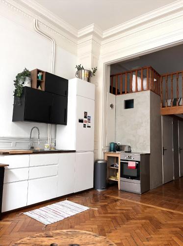 a kitchen with white cabinets and a tv on the wall at Appartement typique Lillois in Lille
