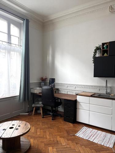 a kitchen with a desk and a chair and a table at Appartement typique Lillois in Lille