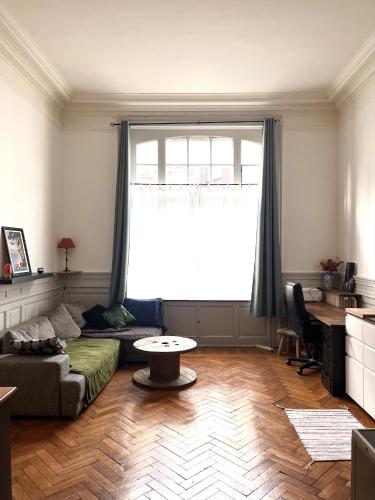 un salon avec un canapé et une table dans l'établissement Appartement typique Lillois, à Lille