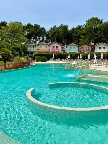 une grande piscine bleue avec toboggan. dans l'établissement Appartement Lacanau Ocean - Golf, à Lacanau