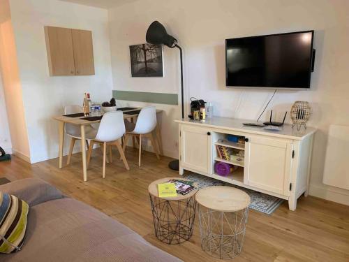 Il comprend un salon doté d'une table et d'une télévision à écran plat. dans l'établissement Appartement Lacanau Ocean - Golf, à Lacanau