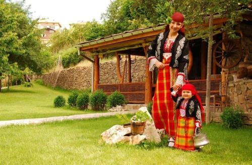 a woman and a child standing in a yard at SPA Hotel Daffi in Smolyan