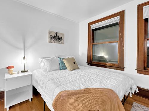 a white bedroom with a bed and a window at Walk to 3 Breweries! 1 Bed Apartment on Grand in Des Moines