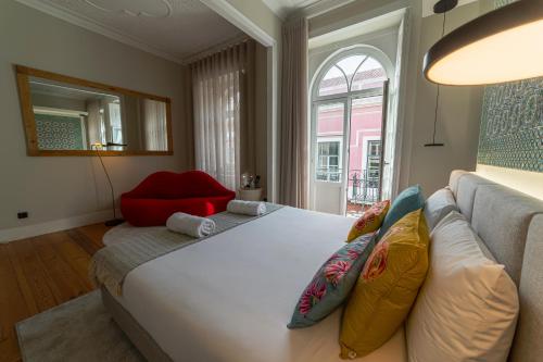 a bedroom with a large white bed and a couch at 19 Tile Ceramic Concept - by Unlock Hotels in Caldas da Rainha