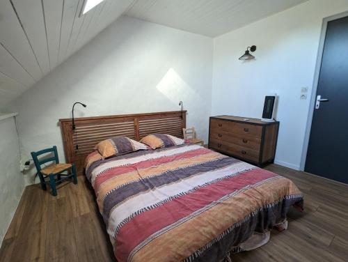 ein Schlafzimmer mit einem großen Bett mit einem hölzernen Kopfteil in der Unterkunft La maison de Joe in Beaumont