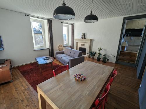 un salon avec une table et un canapé dans l'établissement La maison de Joe, à Beaumont