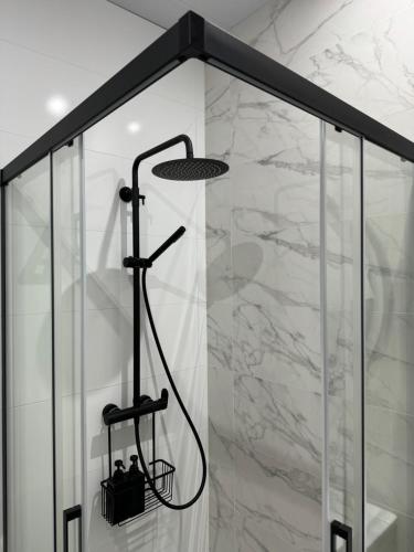 a shower in a bathroom with marble walls at Casa Alma in Montoro