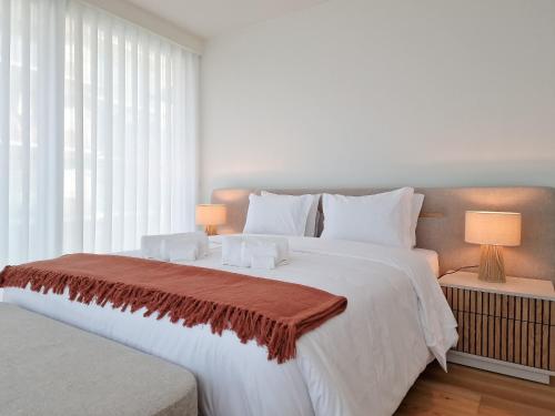 Un dormitorio con una gran cama blanca y una ventana en Bayline Condominium - Heated indoor Swimming pool - SPA - By Bedzy, en Armação de Pêra