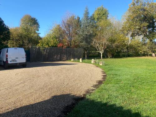 a white van parked in a yard next to a driveway at Chambres et Gîtes Les Deux Chênes près de Bergerac in Le Fleix