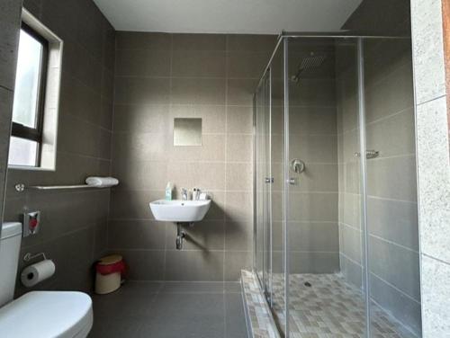 W łazience znajduje się prysznic i umywalka. w obiekcie Epic Springs Bed & Breakfast w mieście Jwaneng