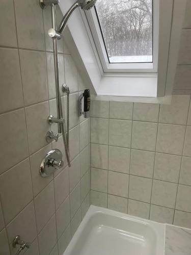 a shower in a bathroom with a window and a tub at Hotel am Naturschutzpark in Undeloh