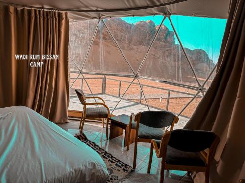 a room with chairs and a view of a mountain at wadi Rum bissan camp in Disah