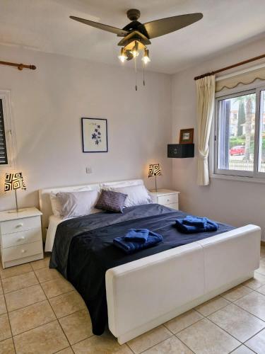 a bedroom with a large bed with a ceiling fan at Givon Palace in Paphos