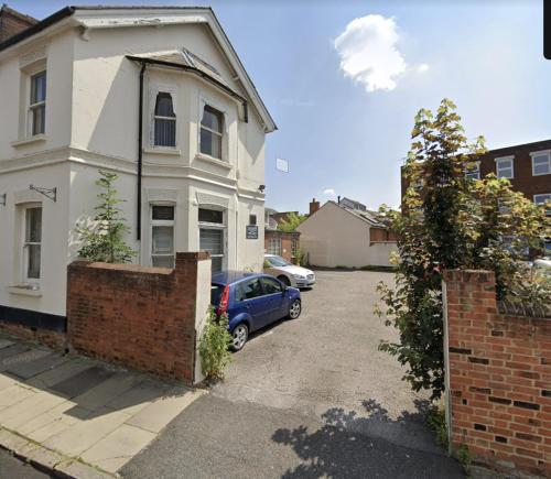 a car parked in front of a white house at Aylesbury Flat 3 with free Parking in Buckinghamshire