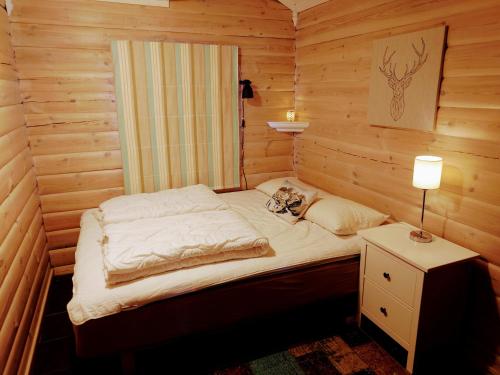 ein kleines Bett in einem Holzzimmer mit einer Lampe in der Unterkunft 100m lift, 2 min swim - Large family cabin in Vradal