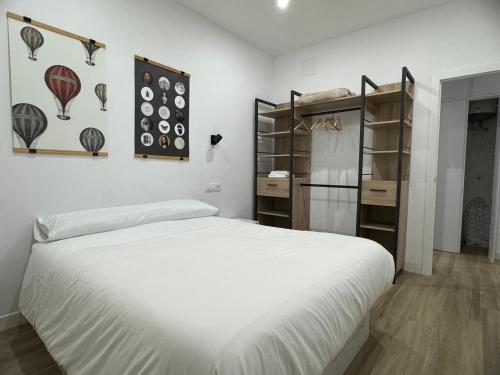 Un dormitorio con una gran cama blanca y estanterías en Casa Luz, en Montoro