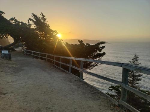 a sunset over the water with a fence and the ocean at Hostal Quiriyuca Sur in Horcón