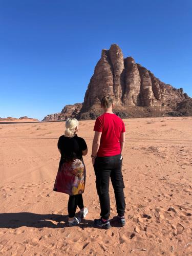 mężczyzna i kobieta stojący na pustyni w obiekcie Zarb Desert Camp w mieście Wadi Rum