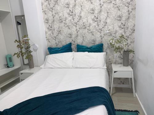 sypialnia z dużym białym łóżkiem z niebieskimi poduszkami w obiekcie CASA PAPAGAYO w mieście Santa Cruz de Tenerife
