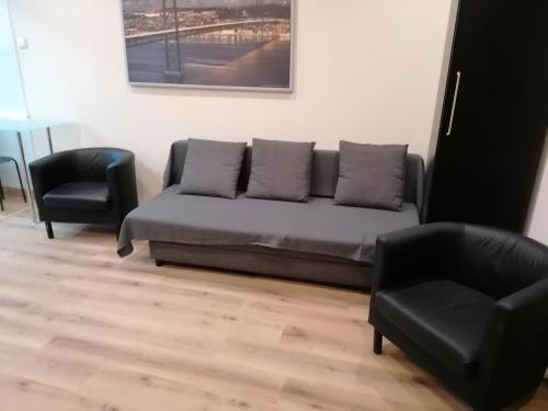 sala de estar con sofá y 2 sillas en Lisbon Heart Santa Marta Apartment en Lisboa