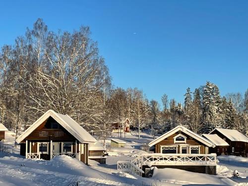 een groep met sneeuw bedekte cottages bij Stuga i Valfjället in Åmotsfors