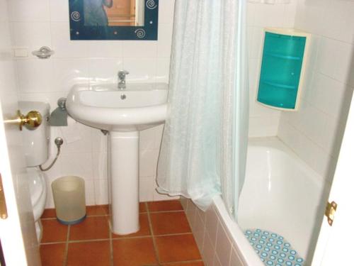 ein Bad mit einem Waschbecken und einem Duschvorhang in der Unterkunft Alojamiento dúplex en Islantilla in Islantilla