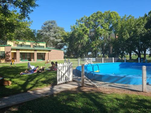 a group of people laying in the grass by a pool at El Descanso in Villa Lía