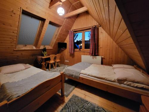 een slaapkamer met 2 bedden in een houten hut bij Willa Gloria in Zakopane