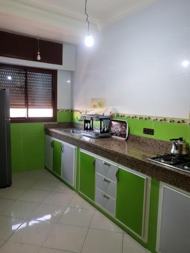 a green and white kitchen with a counter top at Oualidia golden sand in Oualidia
