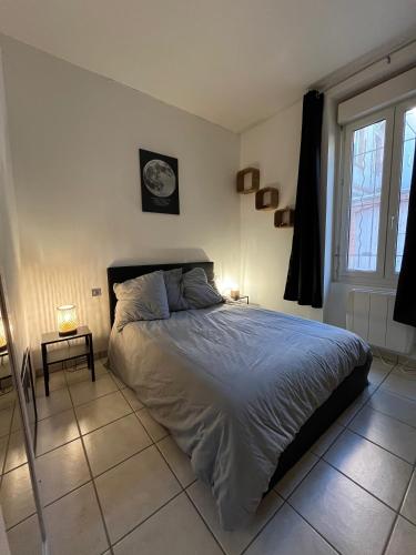 Ce lit se trouve dans une chambre dotée de 2 lampes et d'une fenêtre. dans l'établissement APPT T2 entre Gare Matabiau et Capitole, à Toulouse