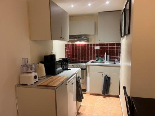 une petite cuisine avec des armoires blanches et un micro-ondes dans l'établissement APPT T2 entre Gare Matabiau et Capitole, à Toulouse