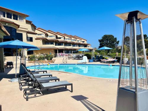 une piscine avec des chaises et des parasols et un hôtel dans l'établissement Luxury Villa - Flora View - Ground Level -Seascape, à Aptos