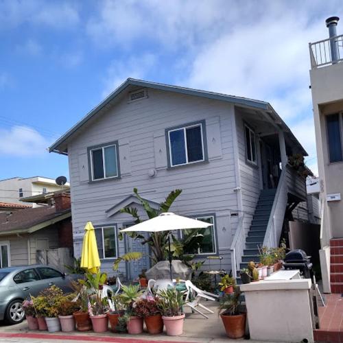 une maison avec un parasol et quelques plantes devant elle dans l'établissement El CARMEL, à San Diego