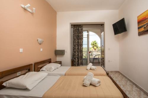 a bedroom with two beds and a balcony at Dimitris studios & apartments in Faliraki