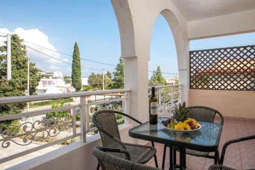 a table with a bowl of fruit on a balcony at Dimitris studios & apartments in Faliraki
