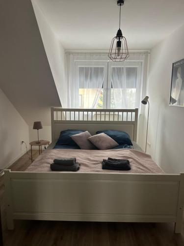 a bedroom with a bed with two towels on it at Apartament Oksford 3 in Okszów