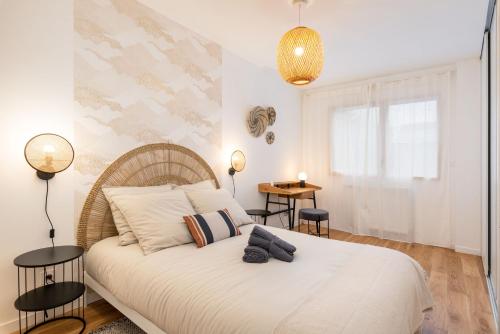 - une chambre avec un grand lit blanc et deux lampes dans l'établissement Les Cocons Montchat, à Lyon