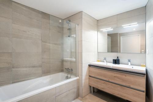 La salle de bains est pourvue d'une baignoire, d'un lavabo et d'un miroir. dans l'établissement Les Cocons Montchat, à Lyon