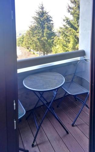 a table and two chairs on a porch with a window at Apartmány Julinka in Říčky