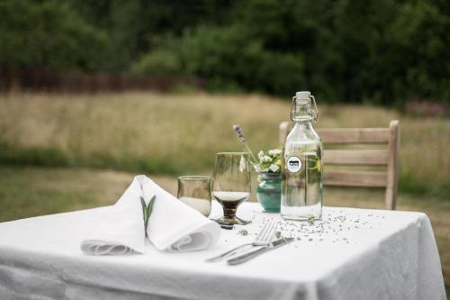 una mesa blanca con una botella de vino y copas en Borkhult Lapphem, en Åtvidaberg
