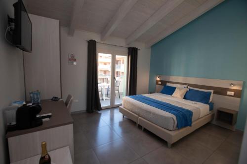 Schlafzimmer mit einem Bett mit blauer Wand in der Unterkunft La Perla Amantea in Amantea