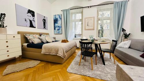 布拉格的住宿－Kampa park Apartment，一间卧室配有一张床、一张桌子和一张沙发