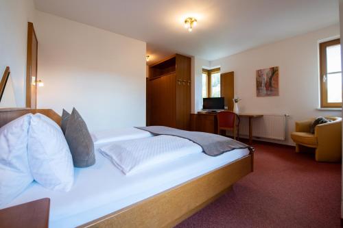グミュント・イン・ケルンテンにあるHotel Restaurant Platzerのベッドとデスクが備わるホテルルームです。